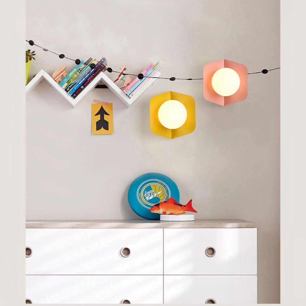 Chambre d enfant avec appliques rose et jaune au-dessus d une commode blanche