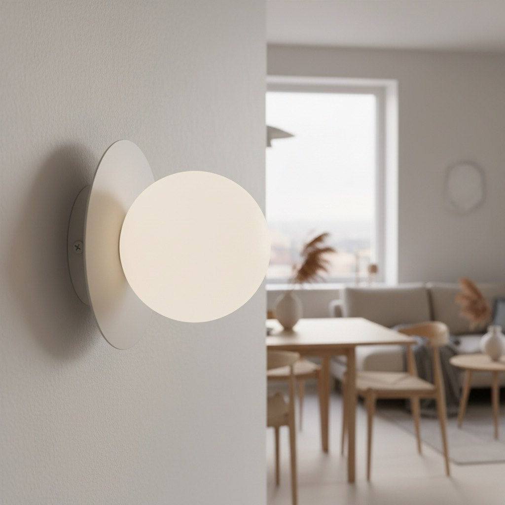 Applique allumée fixée sur un mur, intérieur clair avec table en bois et fenêtre en arrière-plan