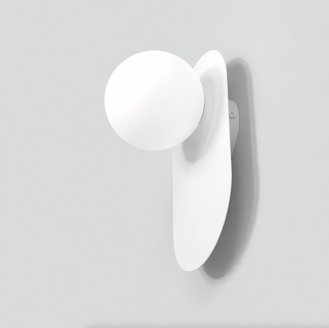 Vue en plongée révélant la sphère opaline fixée sur la plaque allongée blanche.