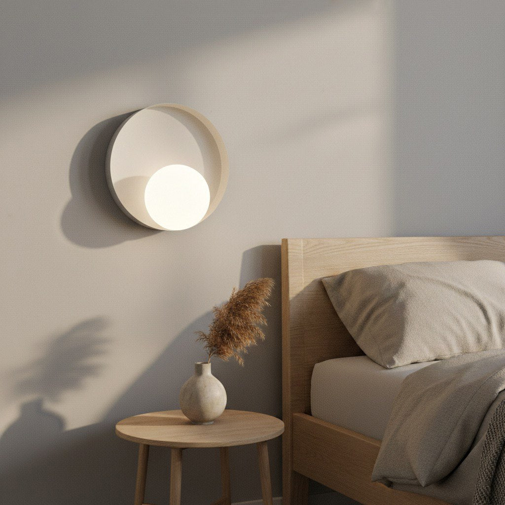 Mise en ambiance chambre avec applique allumée au-dessus d'une table de chevet