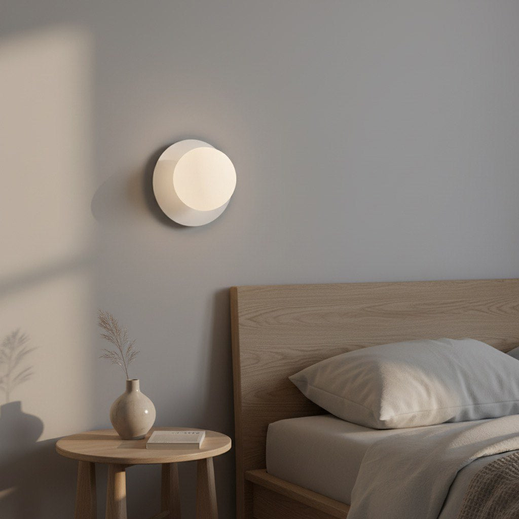 Ambiance chambre avec applique allumée au-dessus d'une table de chevet en bois