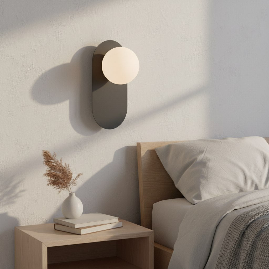 Mise en ambiance dans une chambre, applique allumée au-dessus d'une table de chevet