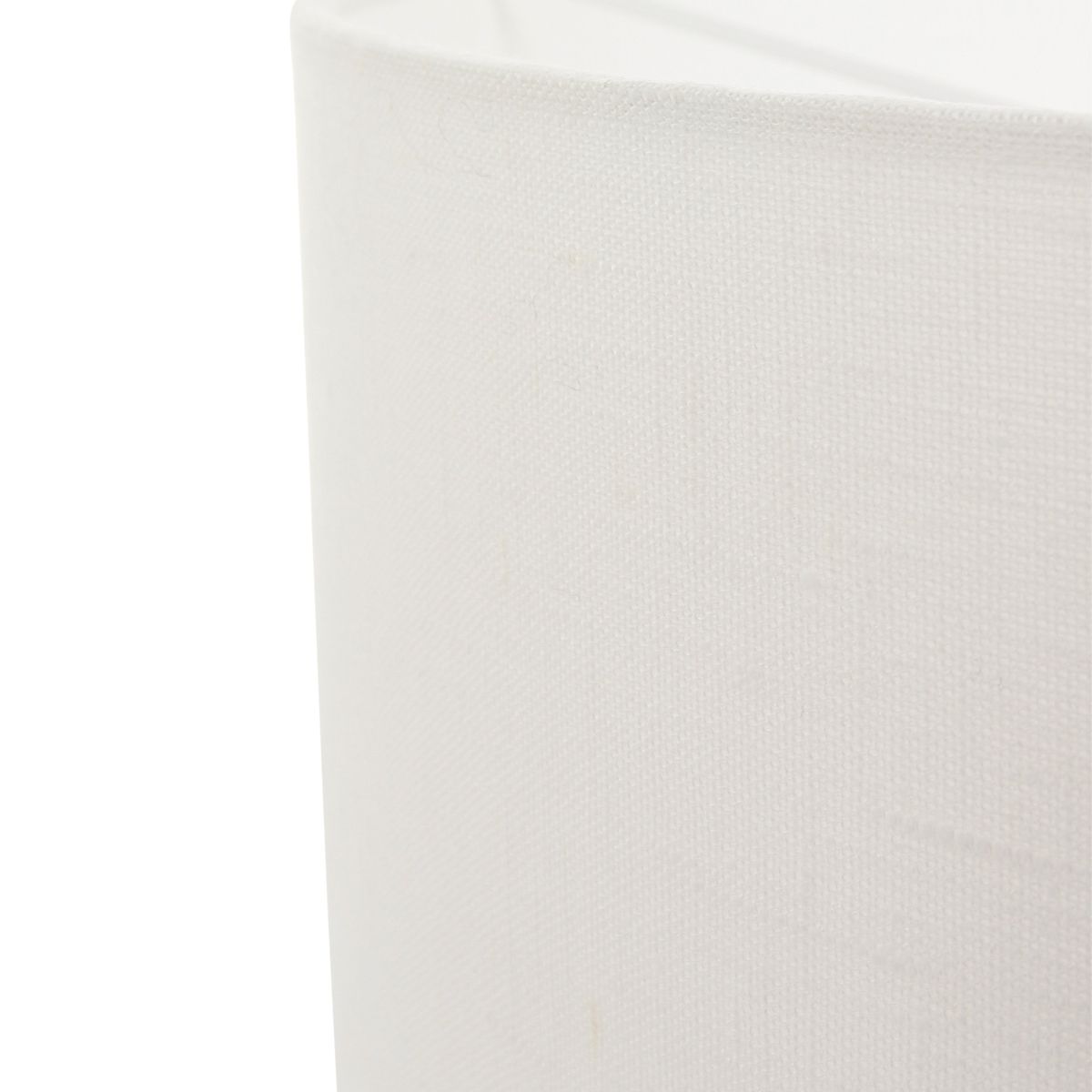 Gros plan sur la texture du tissu en lin blanc de l’abat-jour.