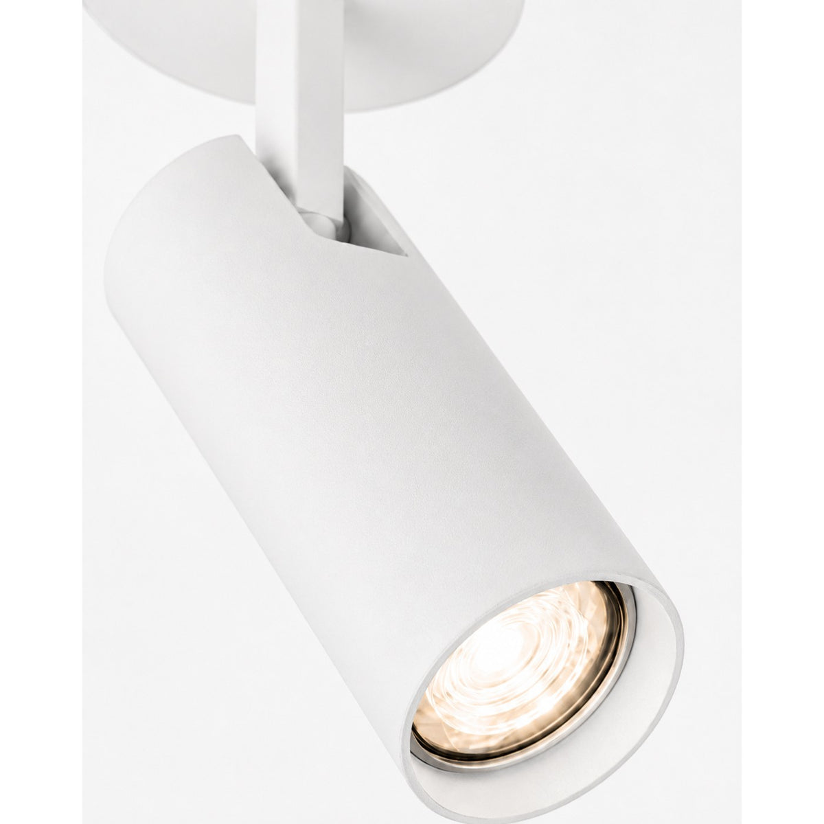 Détail rapproché du cylindre blanc et de la lentille éclairée.