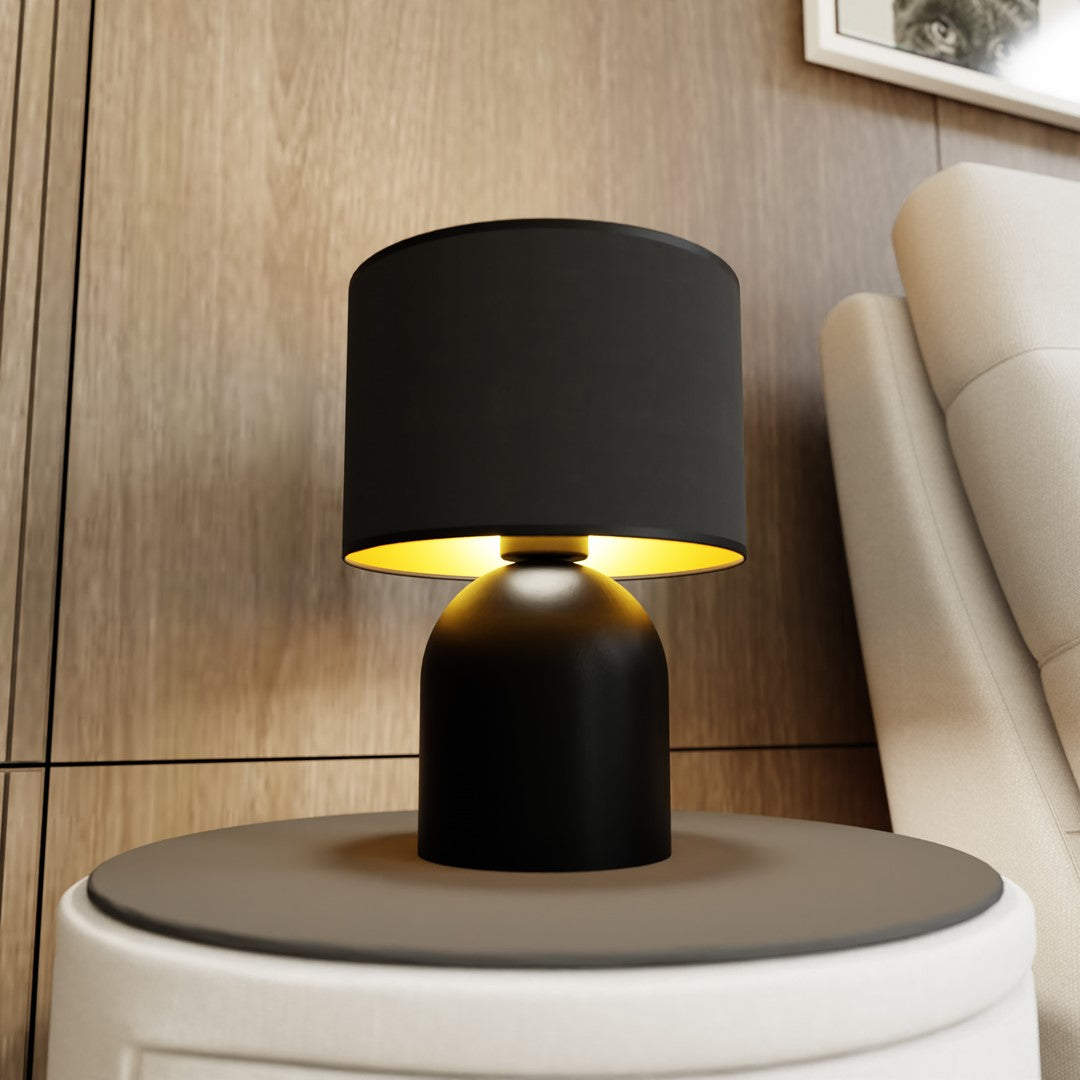 Lampe allumée posée sur table d'appoint, près canapé et tête de lit en bois.