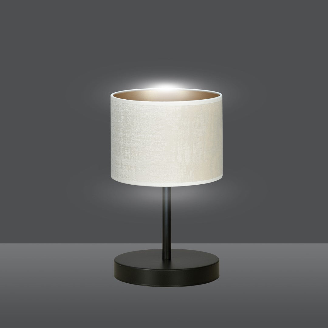 Lampe de chevet blanche allumée sur fond gris, lumière diffusée vers le haut.