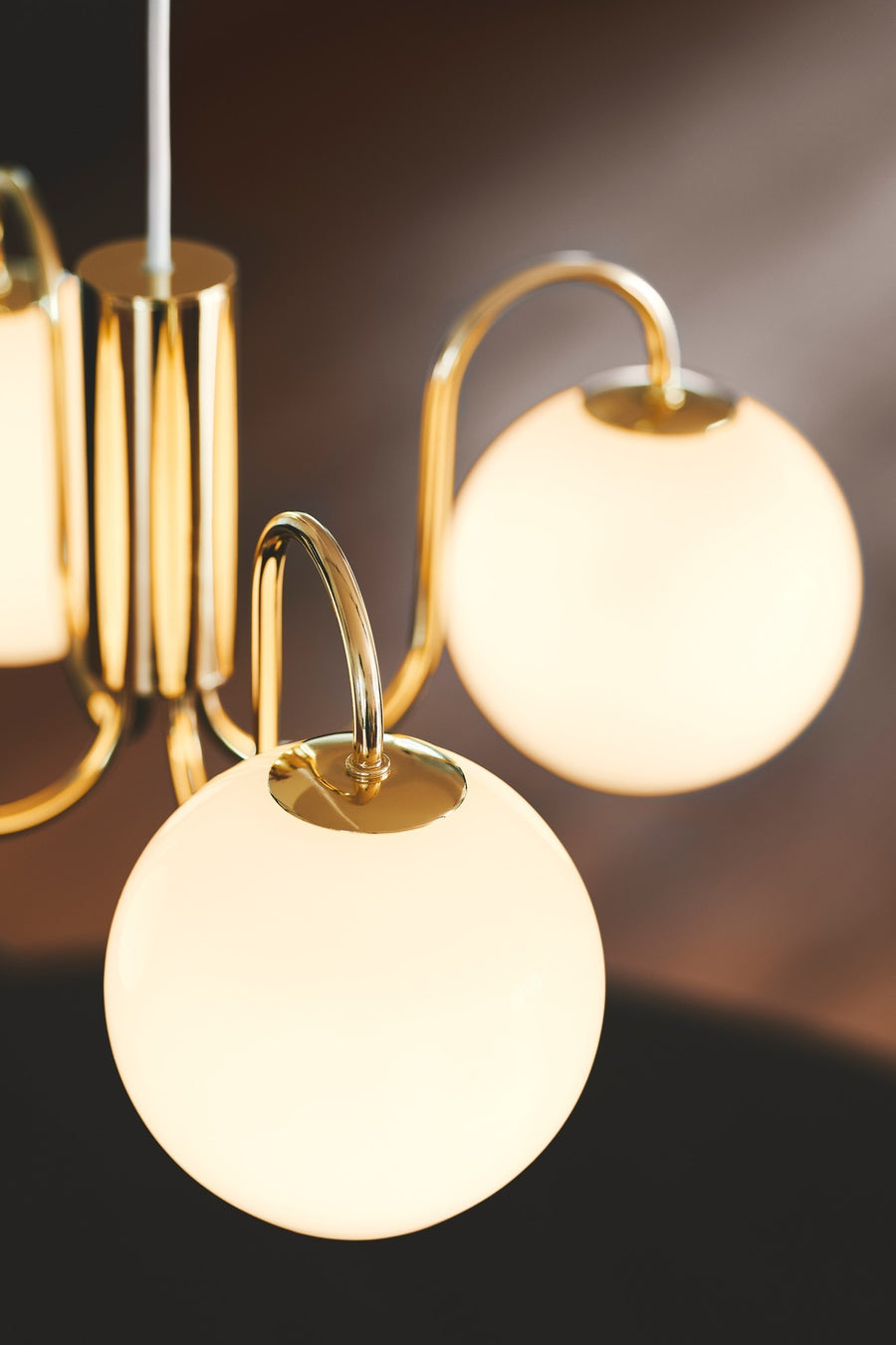 Gros plan sur la finition laiton et un globe de verre allumé émettant une lumière chaude