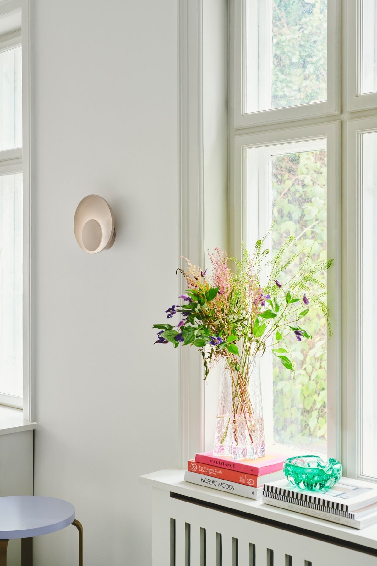 Mise en ambiance dans une pièce claire avec l'applique murale installée près d'une fenêtre