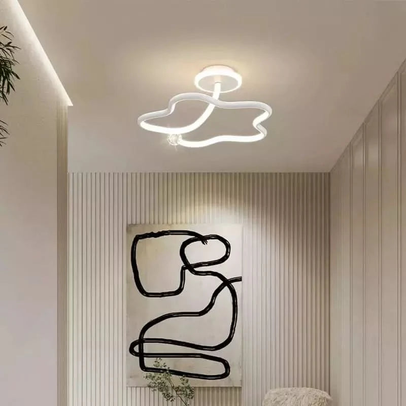 Plafonnier blanc au dessin ondulé devant une peinture abstraite