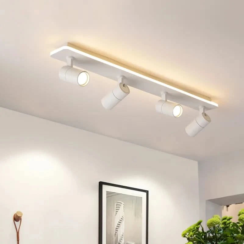 Modèle blanc à quatre spots cylindriques orientables fixé sur un plafond blanc.