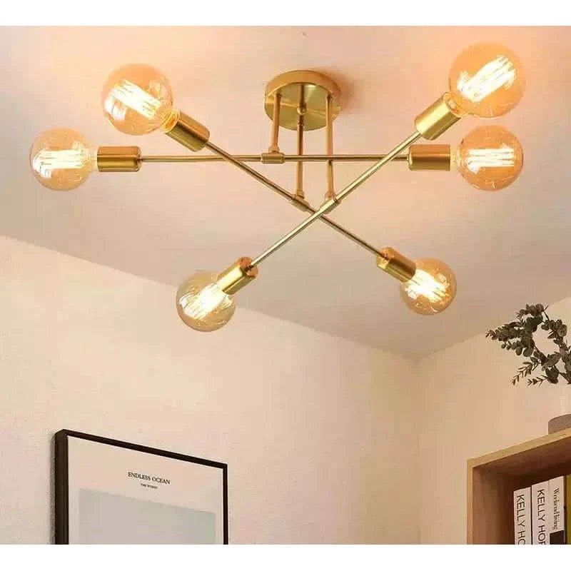 Plafonnier doré à six ampoules transparentes fixé au plafond dans une chambre.
