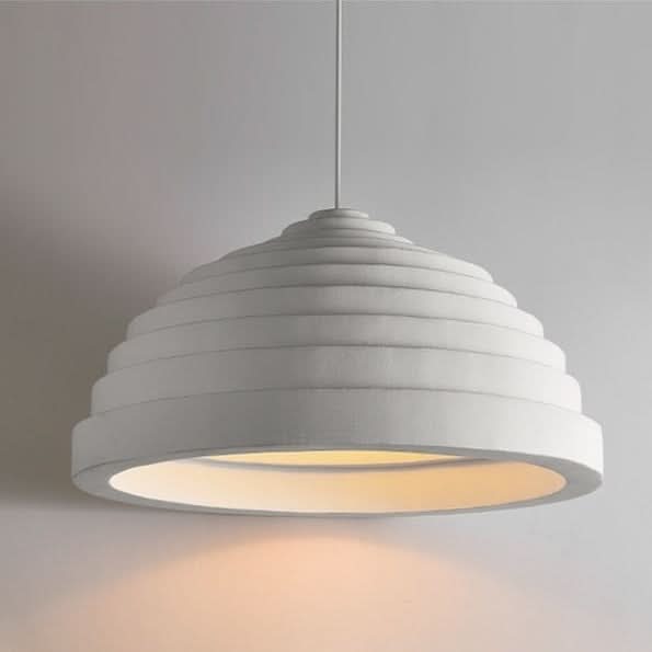 Vue de trois quarts du luminaire, câble fin et lumière chaude projetée.