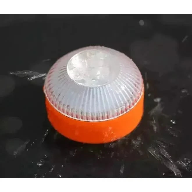 Luminaire orange mouillé posé sur fond sombre, test d'étanchéité.