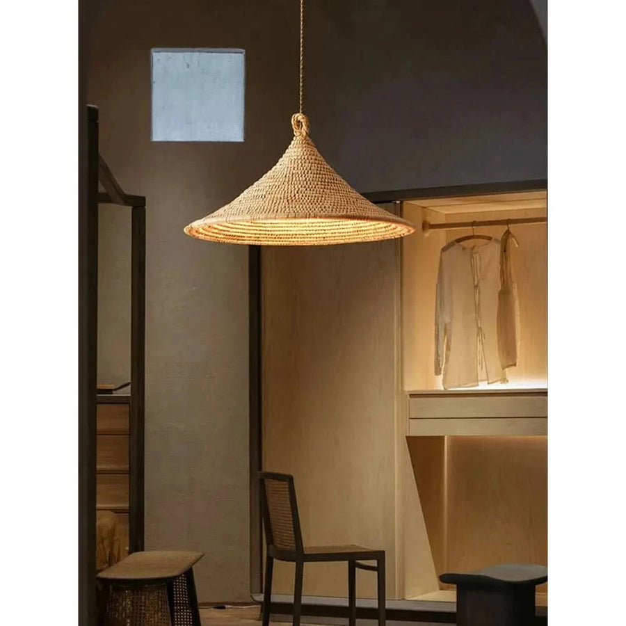 Vue d'ensemble dans un intérieur, dressing en bois et chaise cannée sous la suspension.