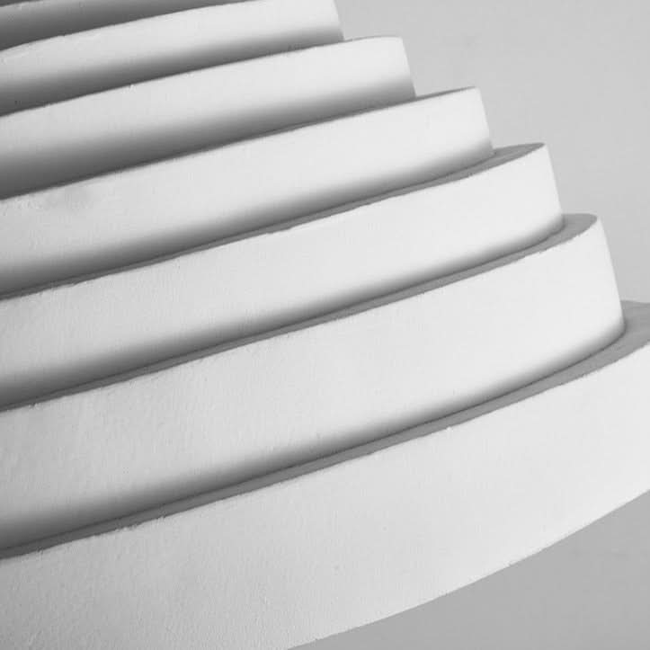 Détail macro des anneaux empilés formant des gradins blancs mats.