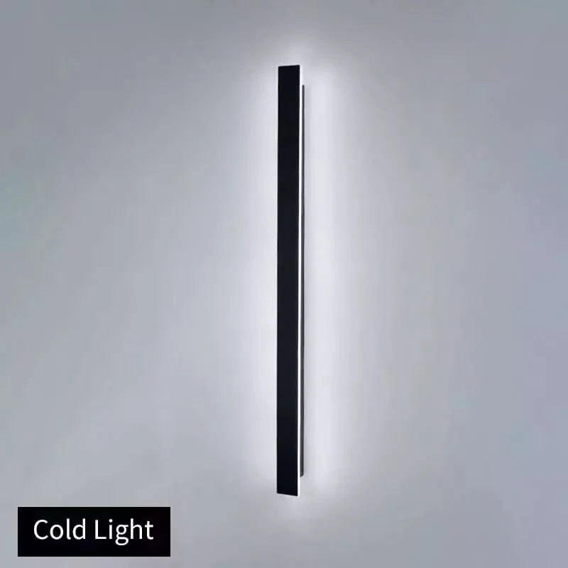 Produit de face en lumière froide, longue applique murale noire éclairant un mur gris.