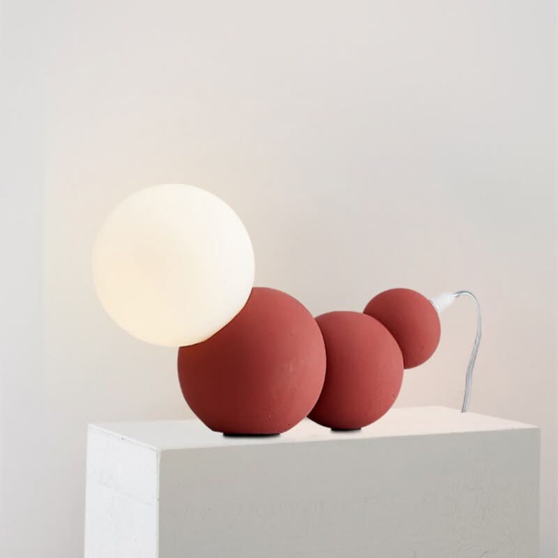 Modèle terracotta sur socle blanc, trois globes empilés en béton mat