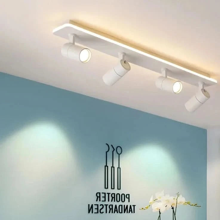 Vue de biais d'un luminaire blanc projetant des halos sur un mur bleu.