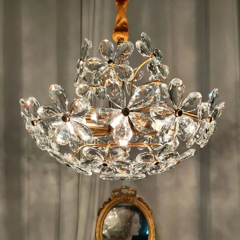 Mise en ambiance avec lustre doré en cristal devant un miroir ancien et un portrait.