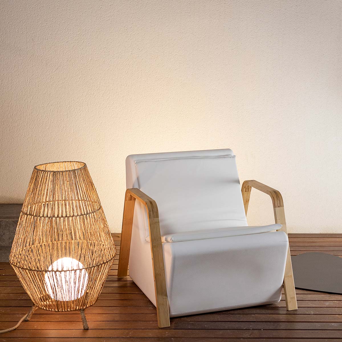 Lampe allumée près d'un fauteuil blanc sur une terrasse
