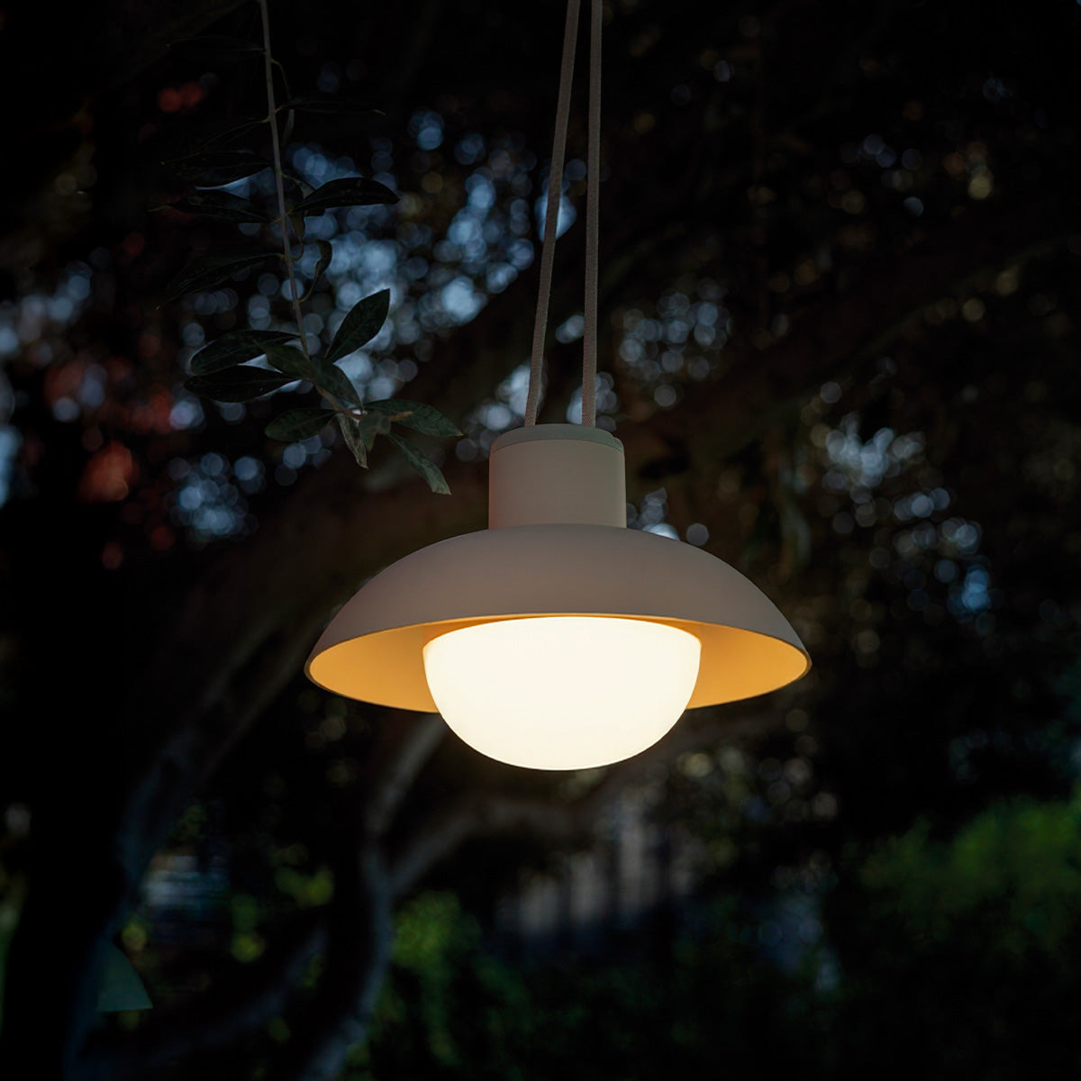 Suspension blanche allumée dans l'obscurité, abat-jour ouvert sur boule lumineuse