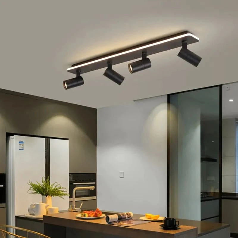 Version noire quatre projecteurs orientables installée au-dessus d'un plan de travail cuisine.