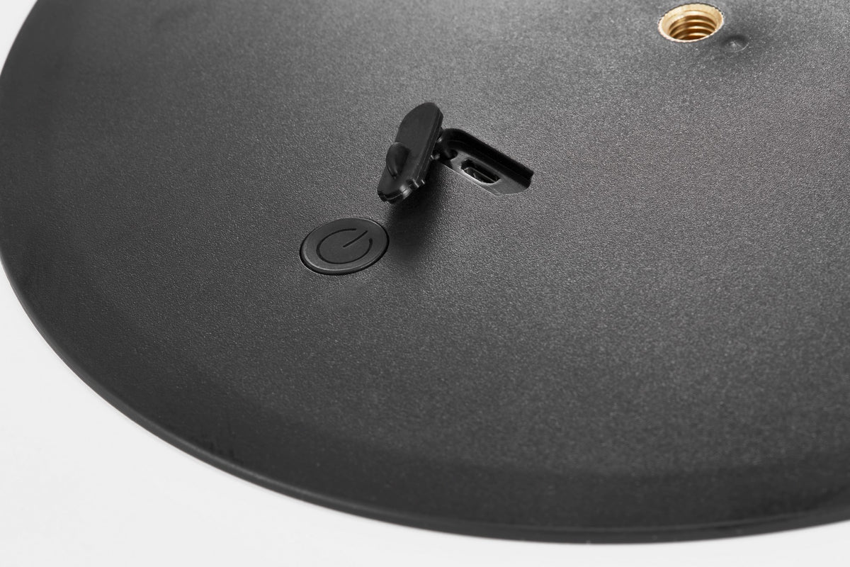 Détail de la base noire avec bouton d'allumage et prise de recharge.
