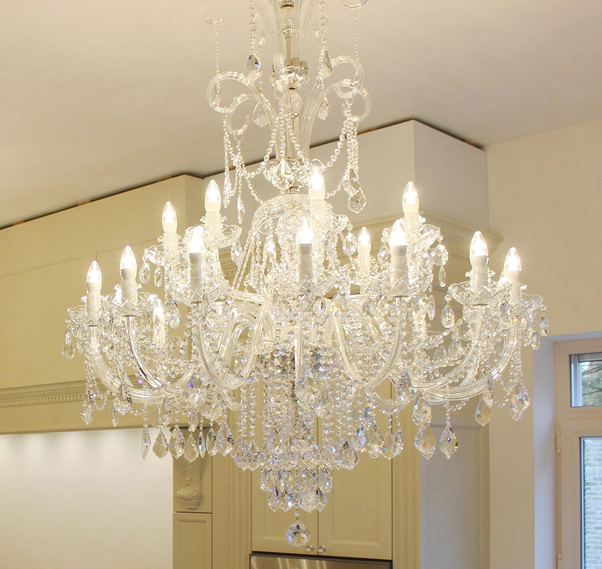 Gros plan sur les bras, les bougies et les gouttes de cristal taillé du luminaire