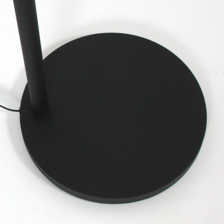Gros plan sur la base ronde noire et le bas du mât, câble d’alimentation visible.