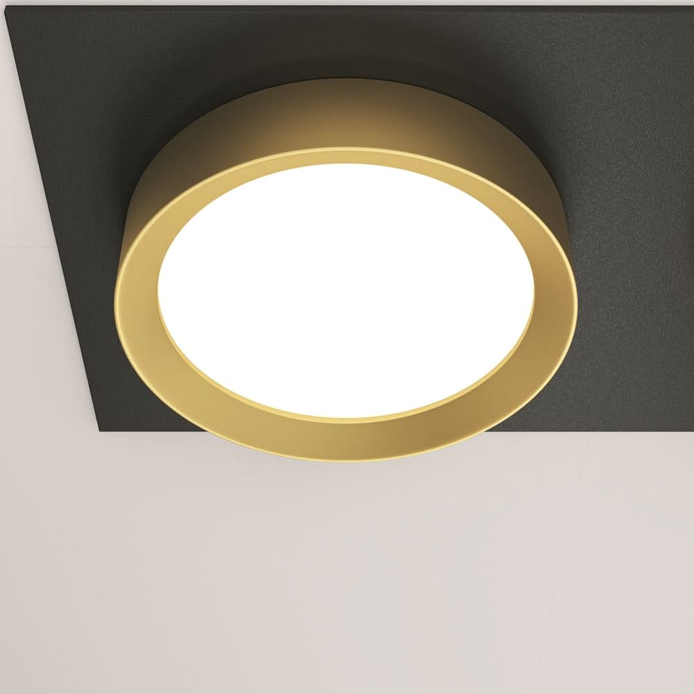 Détail rapproché du cerclage doré et du diffuseur blanc opaque d'un spot