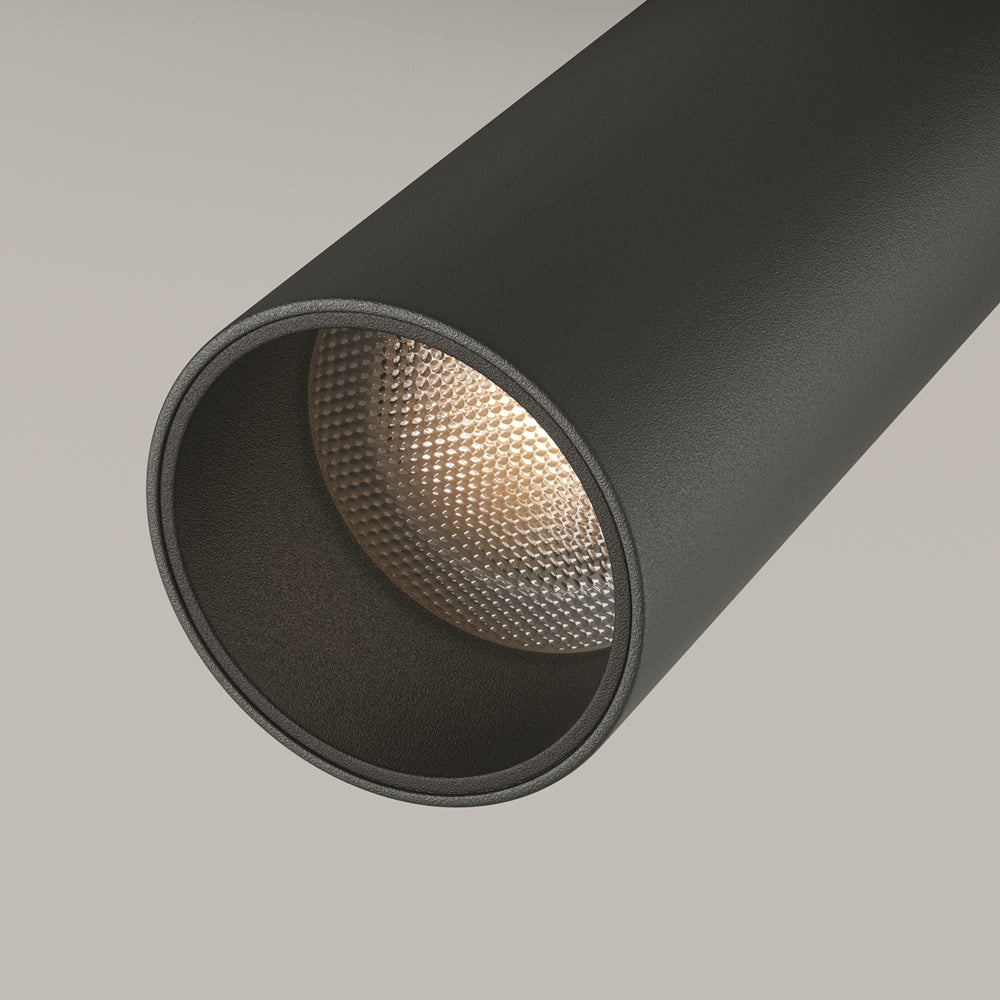 Détail du réflecteur alvéolé doré placé à l'intérieur du corps cylindrique noir mat.