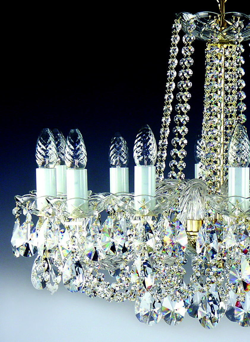 Détail rapproché des bras, bougies et pendeloques de cristal taillé.