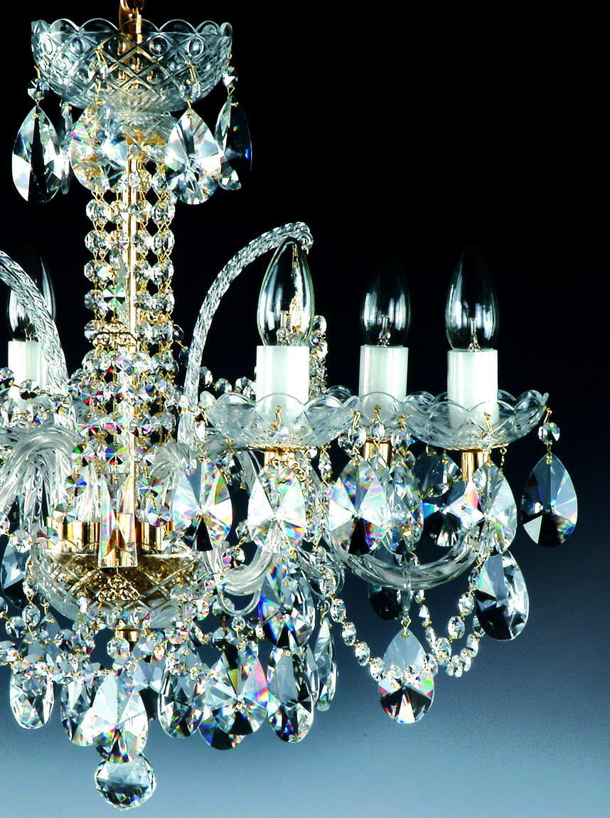 Gros plan sur les bras de verre torsadé et les pampilles irisées du lustre