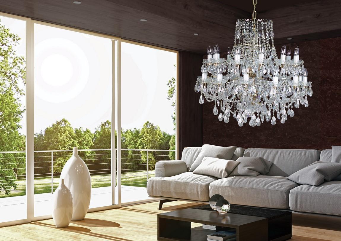 Mise en ambiance salon moderne, lustre suspendu devant baie vitrée et canapé gris.