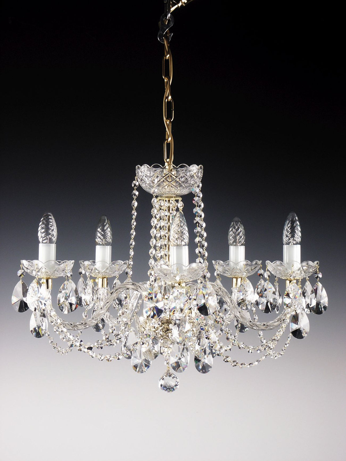 Détail de la chaîne dorée et du système d'accroche au plafond du lustre