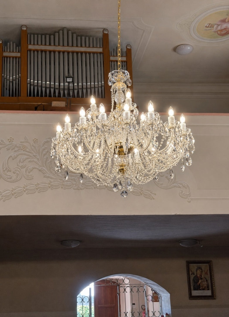 Lustre suspendu dans une église, devant les tuyaux d'un orgue sculpté