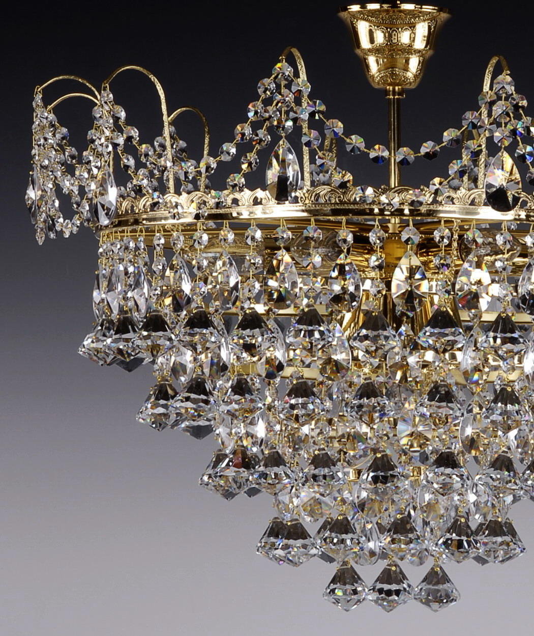 Détail rapproché de la finition laiton doré et des gouttes de cristal taillé suspendues.
