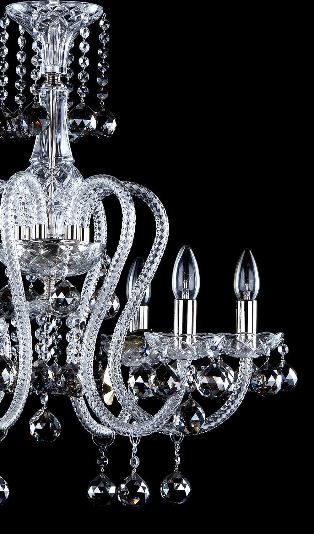Profil rapproché du luminaire, bras recourbés et gouttes de cristal suspendues.