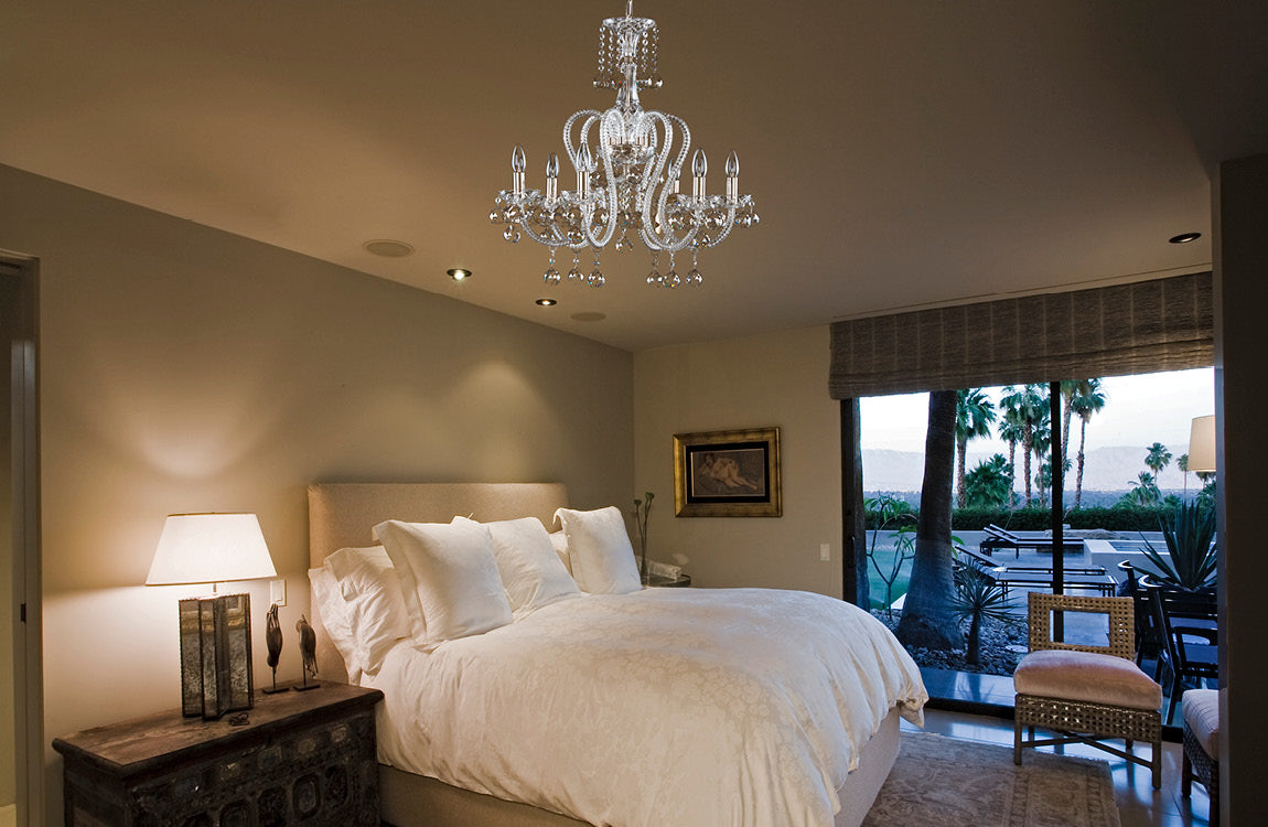 Lustre suspendu au plafond d'une chambre, au-dessus d'un lit blanc, vue d'ensemble.