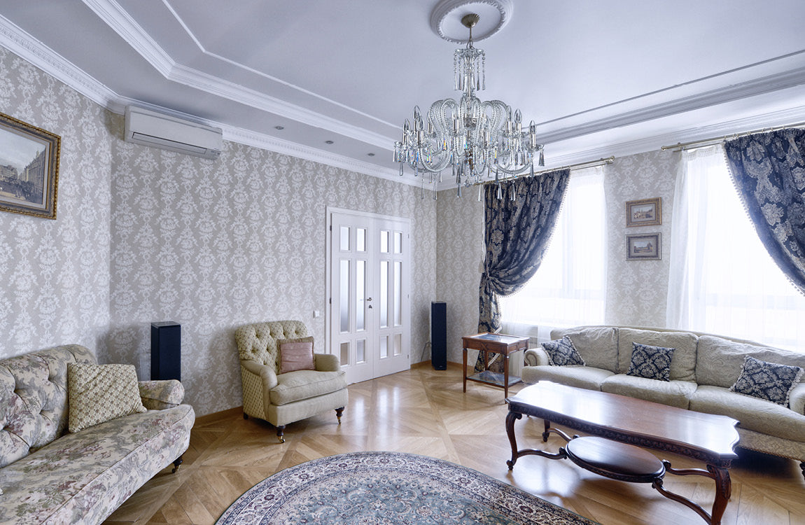 Lustre installé au plafond d'un salon classique avec canapés et rideaux bleus