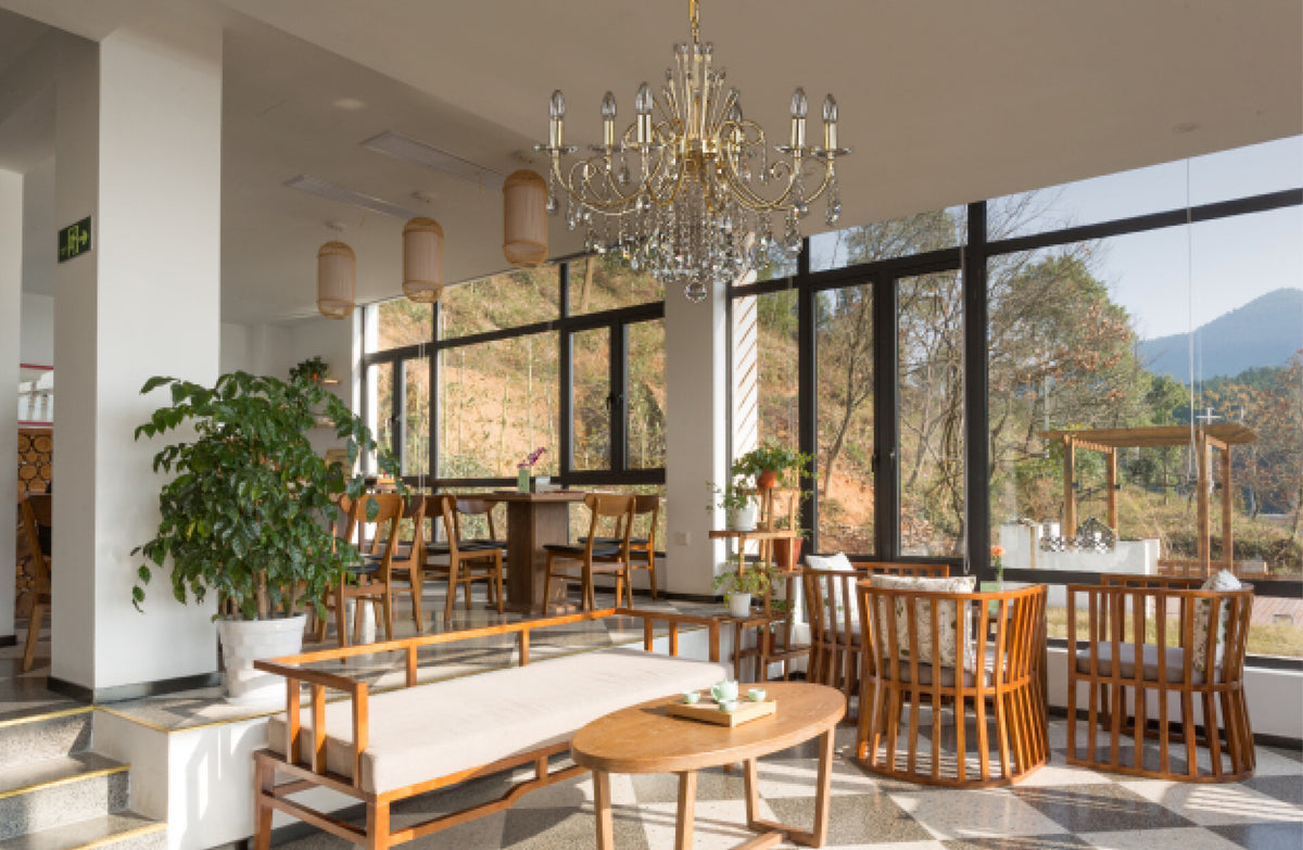 Lustre suspendu au plafond d'un salon lumineux avec grande baie vitrée et mobilier en bois