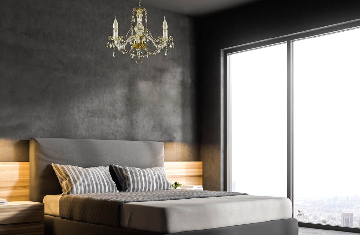 Lustre suspendu au plafond d'une chambre grise au-dessus d'un lit