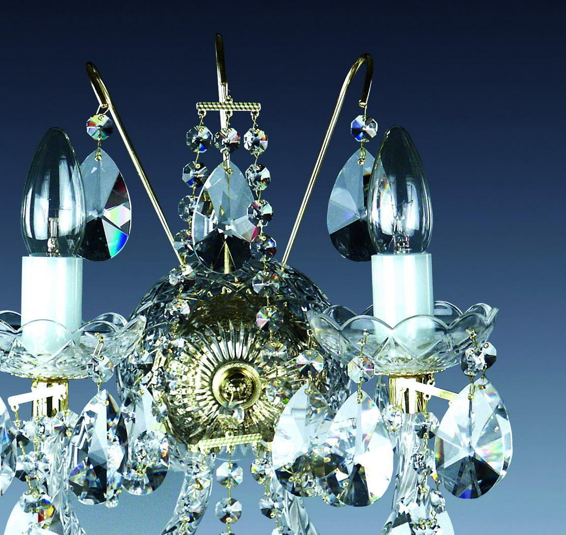 Gros plan du centre doré moulé, bras recourbés et pendentifs en cristal facetté.
