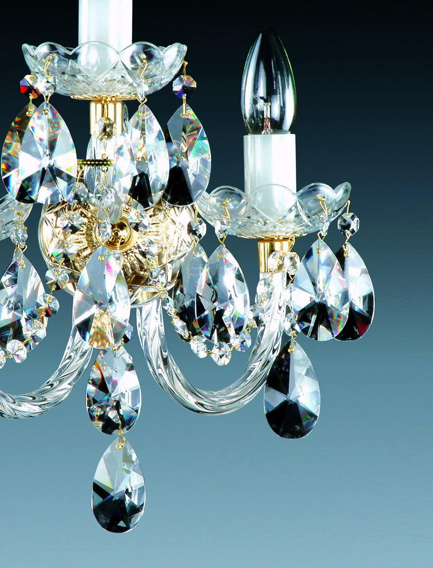 Gros plan sur les gouttes de cristal facettées et la finition dorée de l'applique
