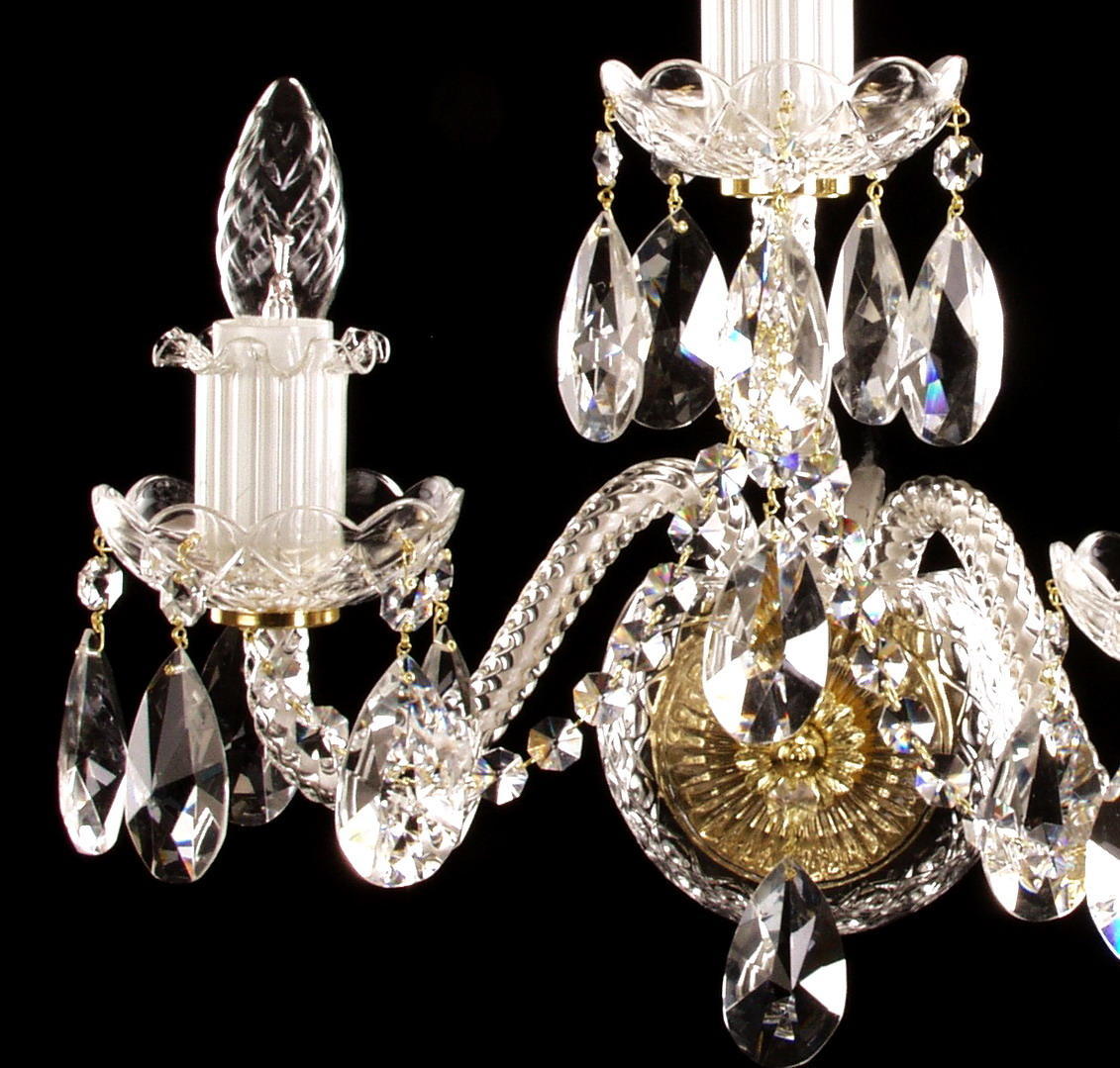 Détail des bras courbés, bobèches festonnées et pendants de cristal taillé.