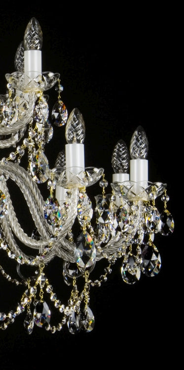 Gros plan sur les douilles blanches, ampoules éteintes et chaînettes dorées du luminaire