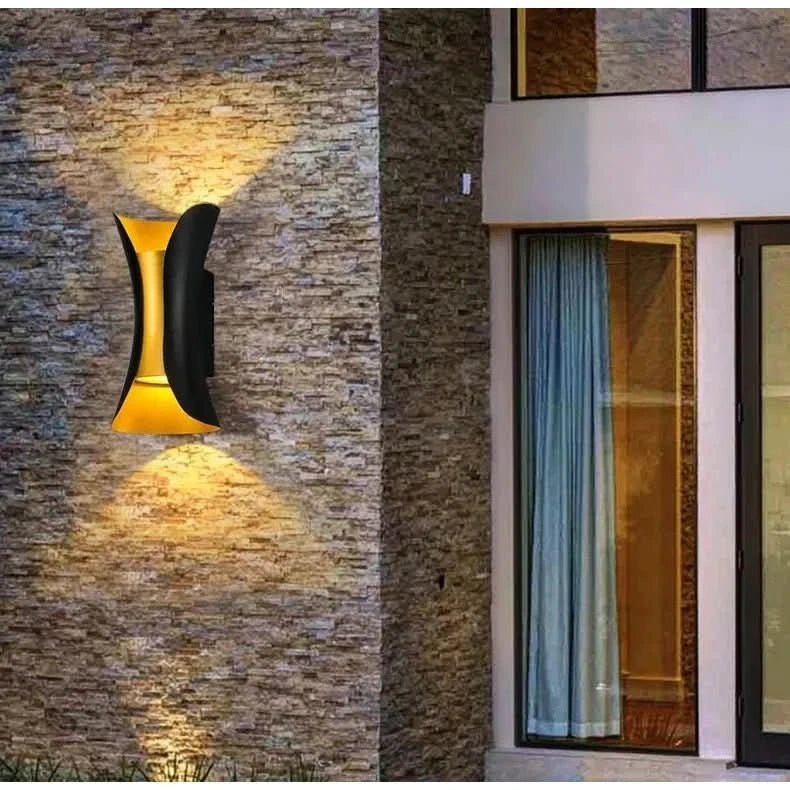 Applique murale fixée sur un mur en pierre, lumière chaude orientée vers le haut et bas