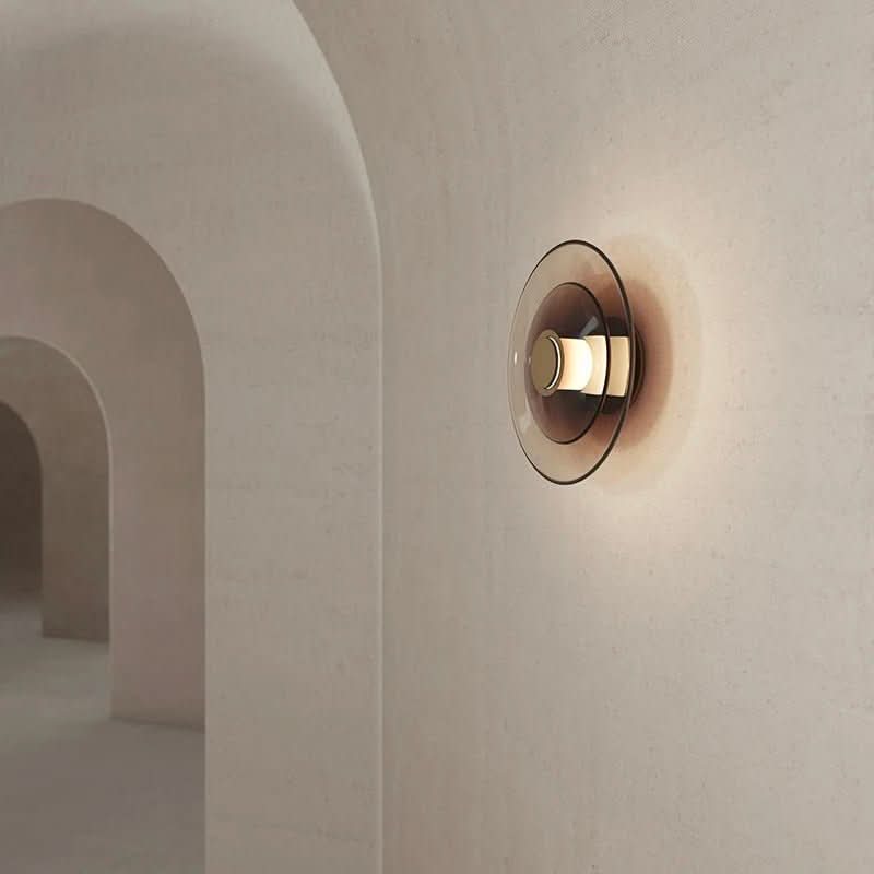 Mise en ambiance dans un couloir voûté, l'applique projette une lumière chaude sur le mur.