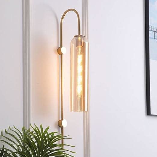 Applique murale dorée, long tube en verre transparent, ampoule allumée, plante verte