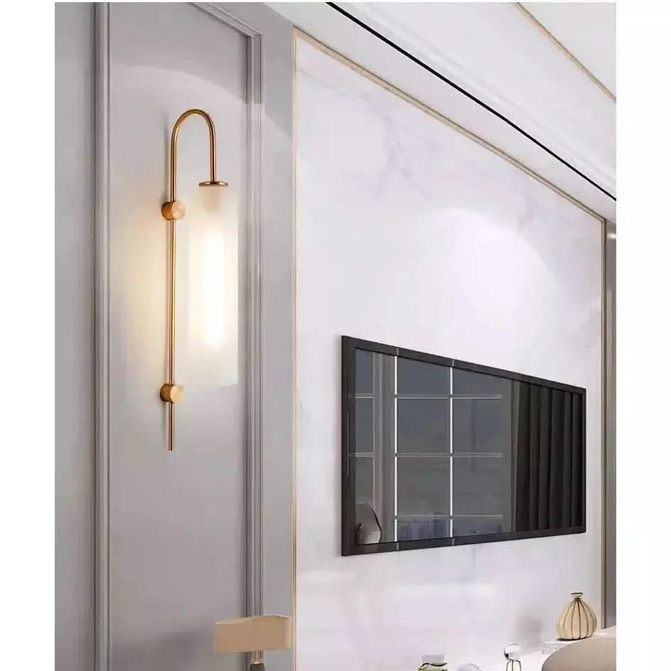 Applique murale dorée, long tube blanc laiteux allumé, reflet dans grand miroir